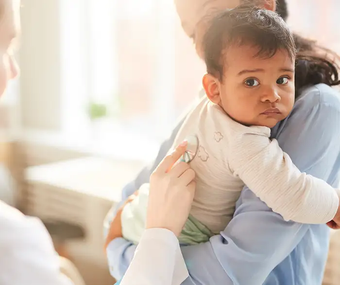 mother holding child during a doctors visit