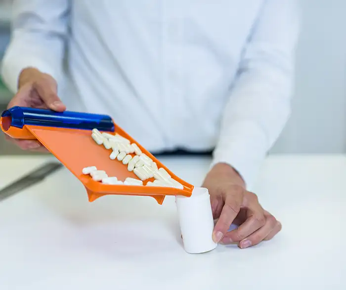 pharmacist putting pills in a bottle