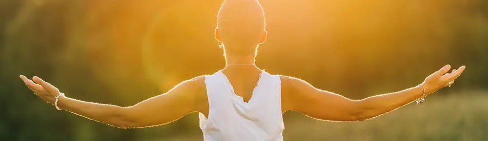 Woman with open arms at Sunset