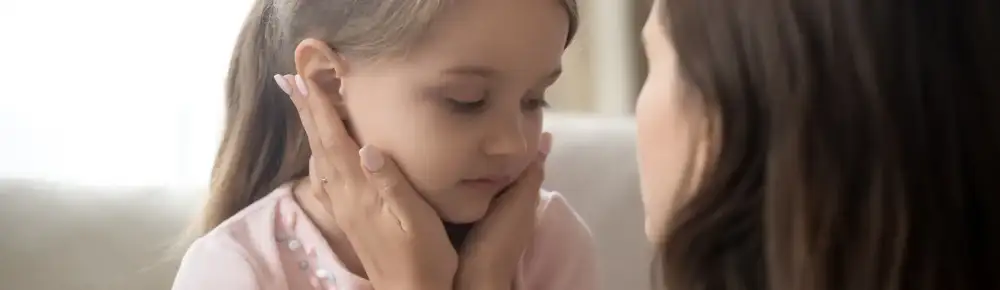 Mother holding her daughter gently by the face