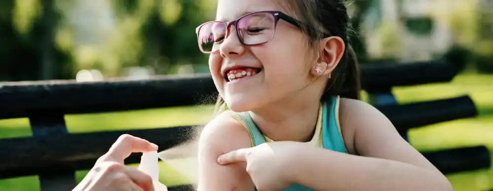 Picture of a child sitting on a park bench getting spray on her shoulder