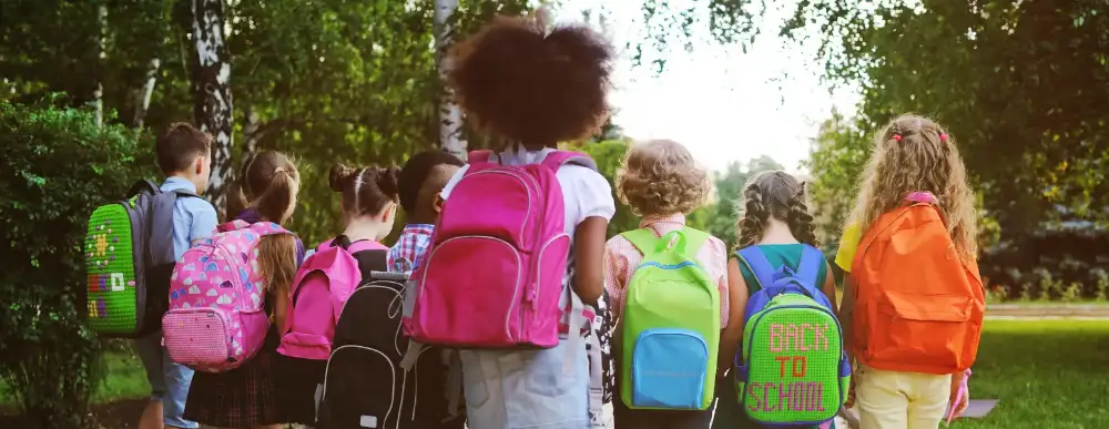 A group of eight kids heading to school with their backpacks