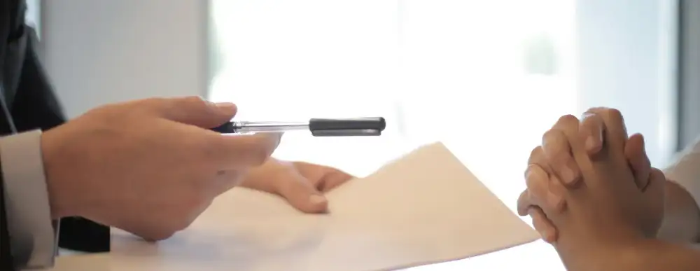 Doctor meeting with a patient has a pen and paper in hand