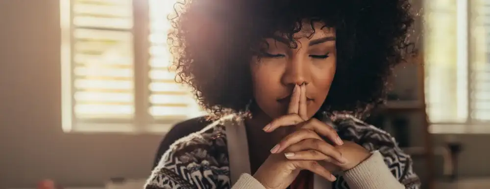 Woman sitting at home deep in thought