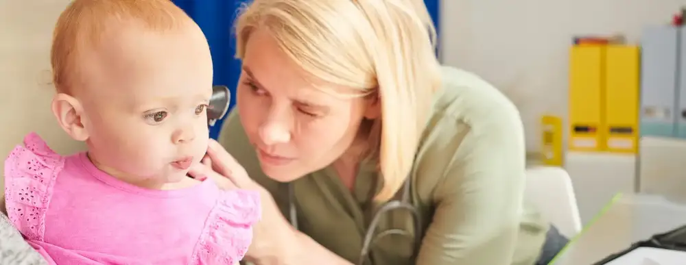 Baby getting a check up, doctor is looking in her ears