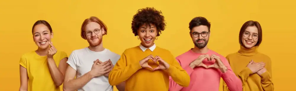 Five people making hand gestures over their heart in the shape of a heart