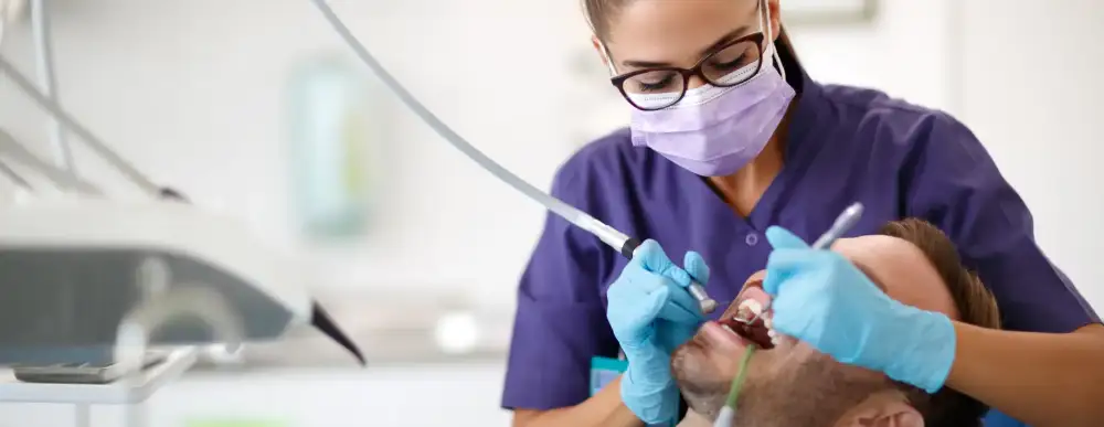 Man getting his teeth cleaned by dentist