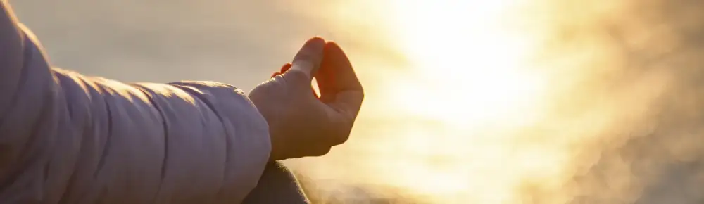 Person meditating by the Lake