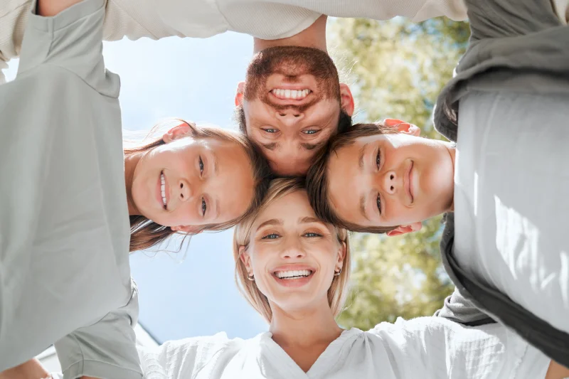 Family of four with heads together.