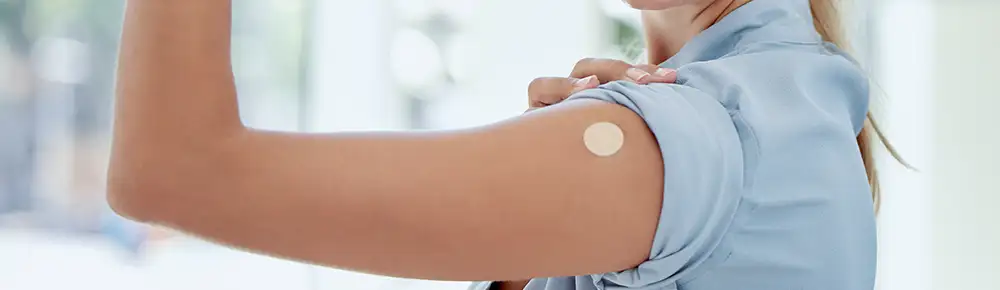 Woman showing her arm after getting a flu shot