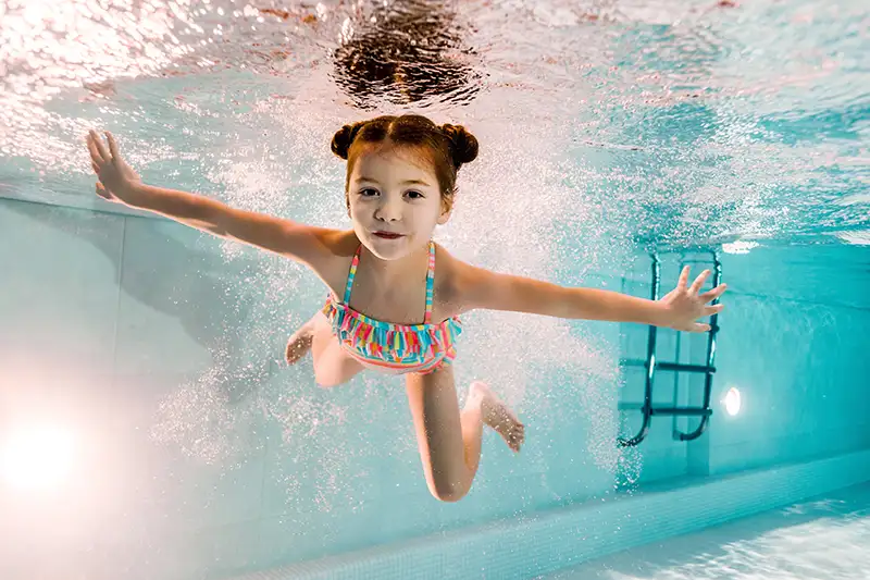 Child swimming underwater looking at the camera
