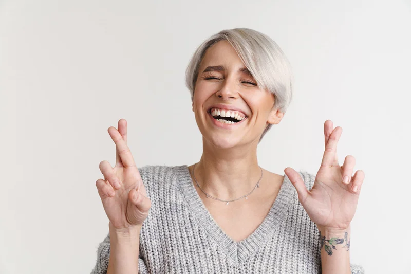 Happy woman crossing her fingers