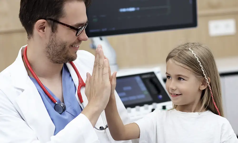 Pediatrician and young girl doing a high five