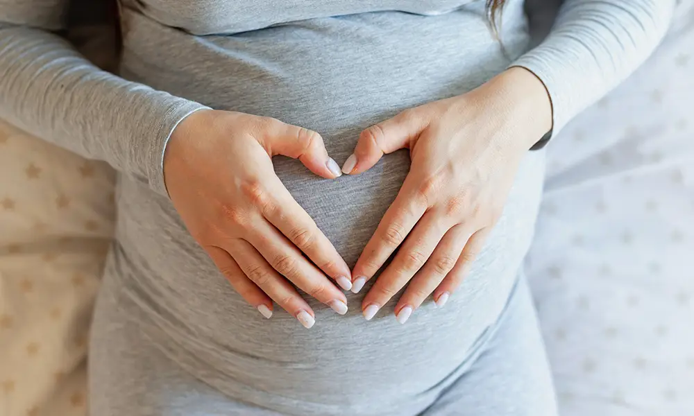 Picture of a pregnant woman with her hands on her belly