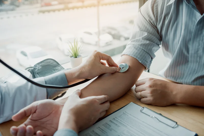 nurse taking pulse of man
