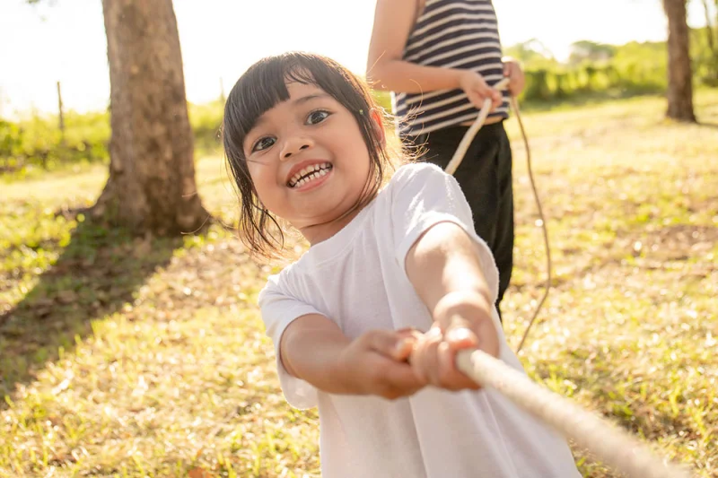 Young child, playing, tug-of-war, and smiling